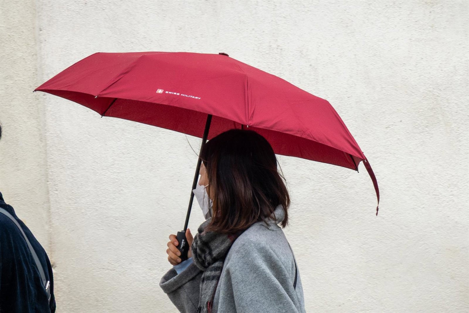 Una persona camina con paraguas en un día de lluvia