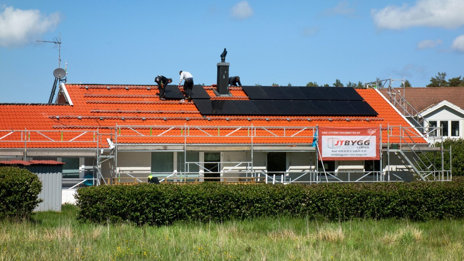 Operarios instalando placas solares en el tejado de una vivienda