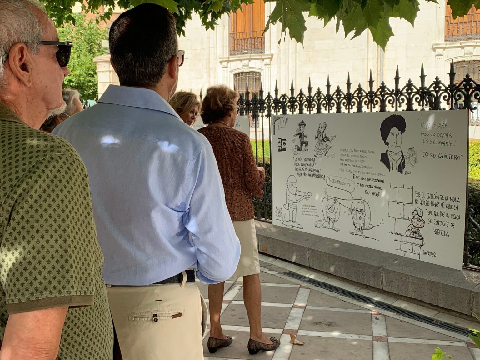 Vecinos leyendo las viñetas de las Chilindrinas colgadas en la verja de la Diputación de Jaén