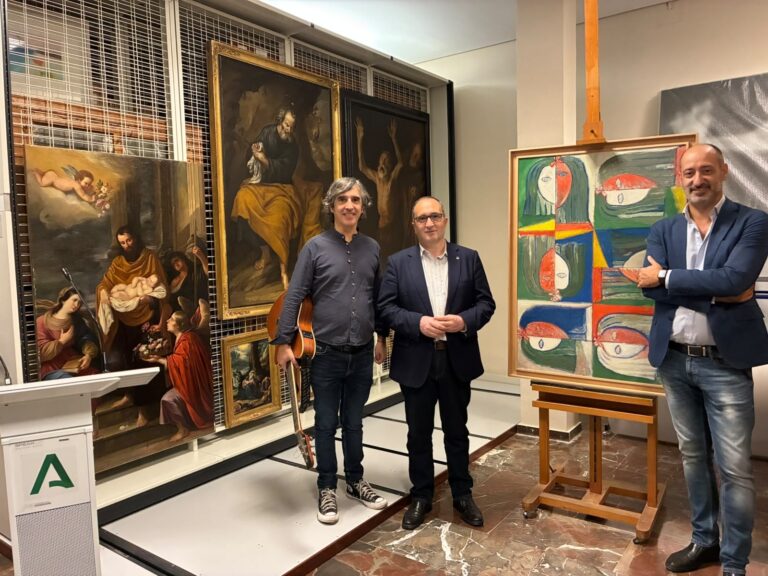 Presentación del ciclo de cantautores en el Museo de Jaén, con un músico con guitarra junto a los cuadros
