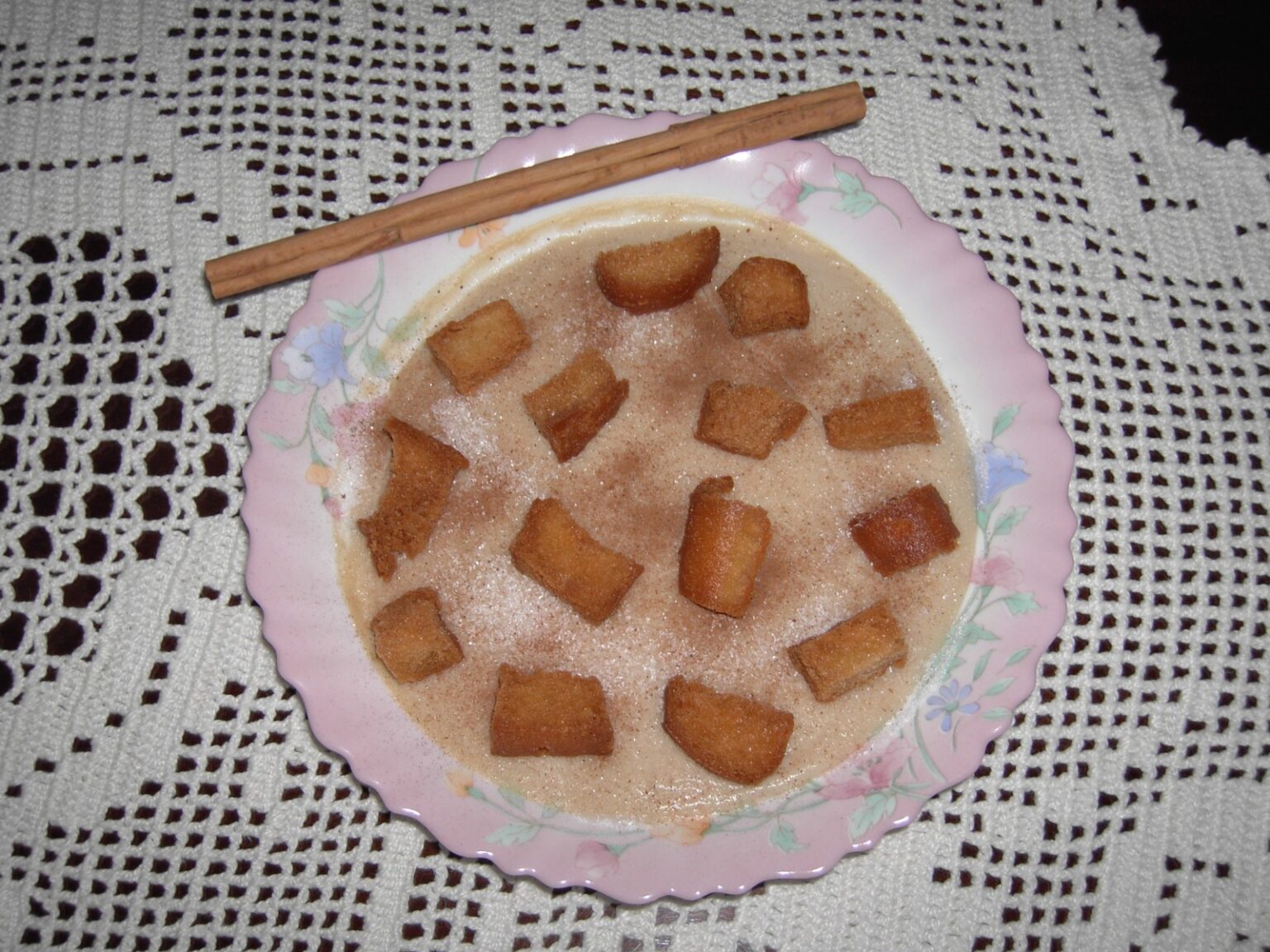 Plato de gachas dulces con tostones de pan frito y canela