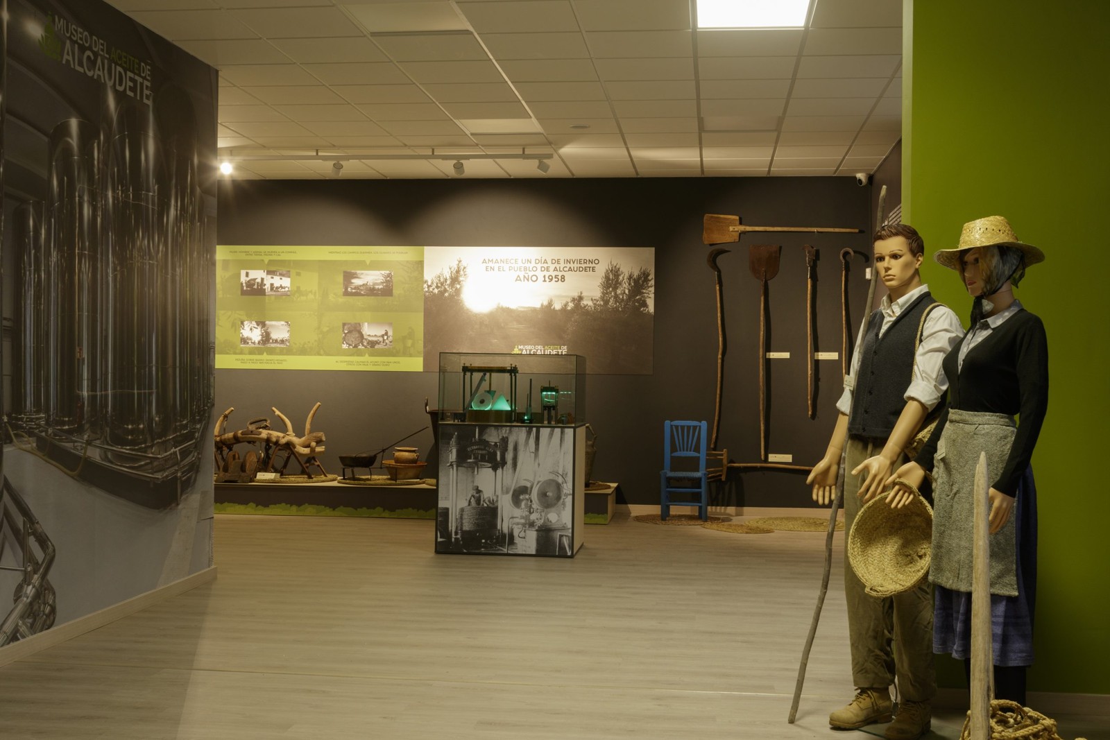 Sala del Museo del Aceite de Alcaudete con maniquíes de aceituneros, aperos y fotografías antiguas