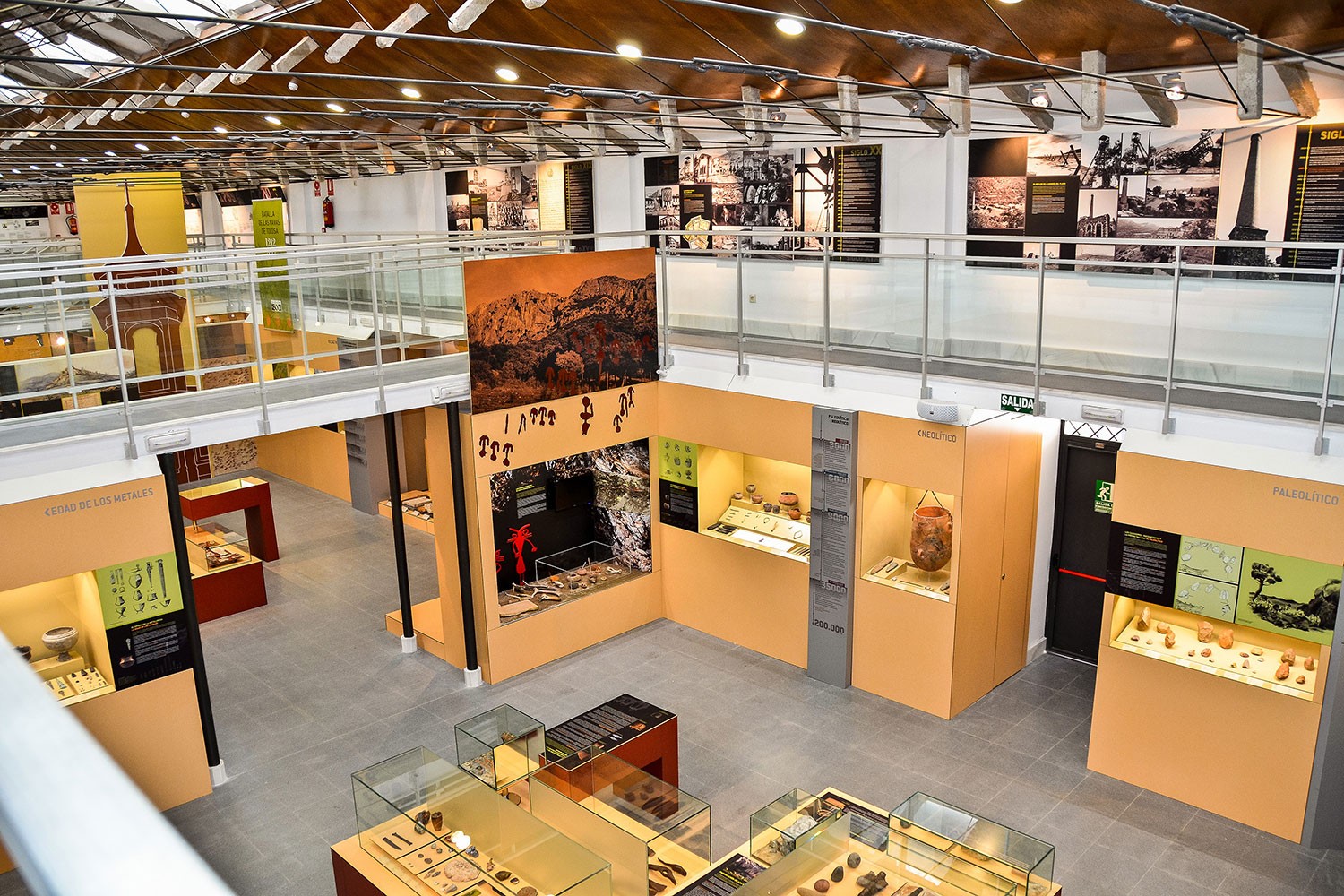 Sala del Museo de La Carolina con vitrinas de prehistoria y galería superior