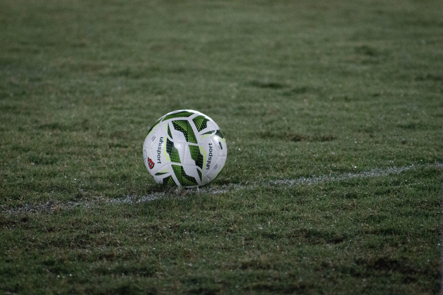 Balón de fútbol sobre el césped de noche